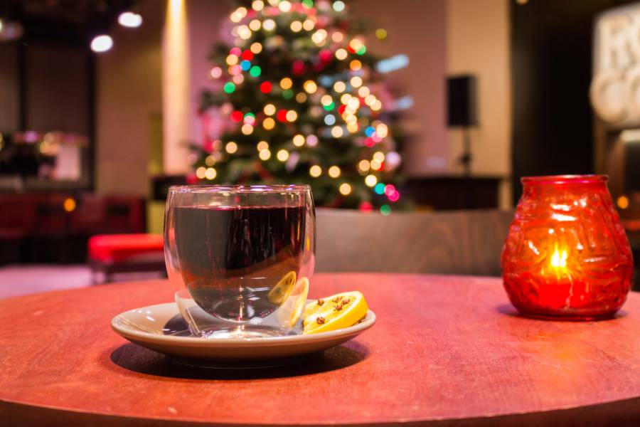 Glass of mulled wine with a Christmas tree visible in the background